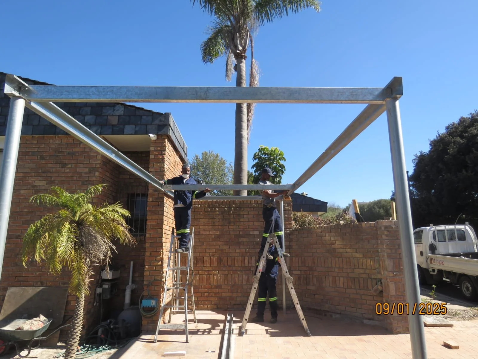 Steel frame structure erected beside a brick commercial-style building